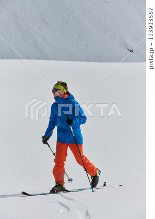 A Skier Scales a Treacherous Alpine Peak 113913587