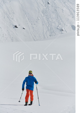 A Skier Scales a Treacherous Alpine Peak 113913589