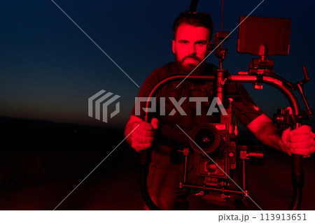 Nighttime Capture: Professional Videographer Films Athletes Running in Red-Lit Darkness 113913651