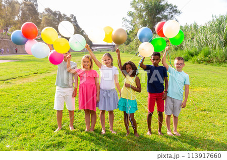Children with balloons on field 113917660