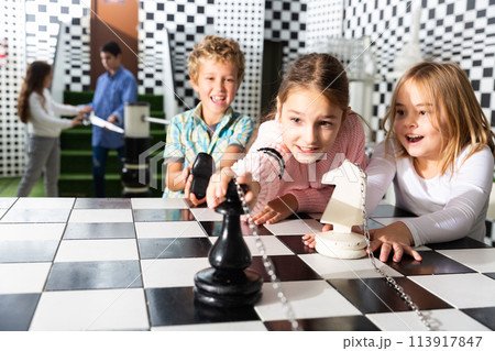 Tweens trying to get out of escape room stylized under chessboard 113917847