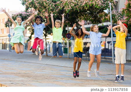 Group of cheerful young girls and boys jumping together 113917858
