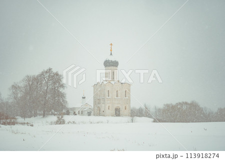 a church in winter in the middle of a snow-covered field 113918274