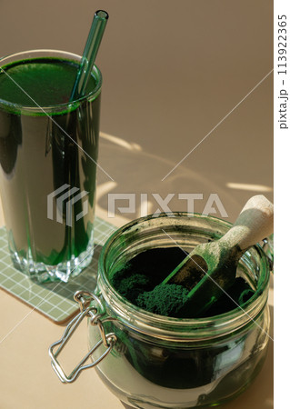 Natural organic green spirulina algae powder drink on neutral beige background. Chlorella seaweed vegan superfood cocktails smoothie supplement source and detox drinking. Innovative ingredient Natural organic green spirulina algae powder drink on neutral beige background. Chlorella seaweed vegan superfood cocktails smoothie supplement source and detox drinking. Innovative ingredient 113922365