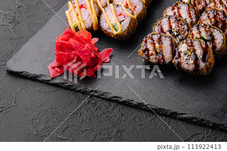Set of baked sushi rolls with wasabi and ginger on black Set of baked sushi rolls with wasabi and ginger on black 113922413