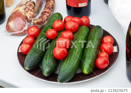 Plate of natural foods with cherry tomatoes, cucumbers, and green onions Plate of natural foods with cherry tomatoes, cucumbers, and green onions 113925675