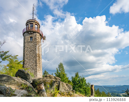 The stone lookout tower of Prosecsky Hreben stands on rocky terrain against a partly cloudy sky, offering a potential view of the surrounding landscape. 113926888