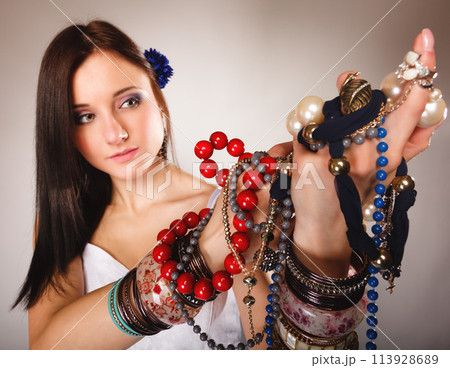 summer girl with plenty of jewellery, beads in hands 113928689
