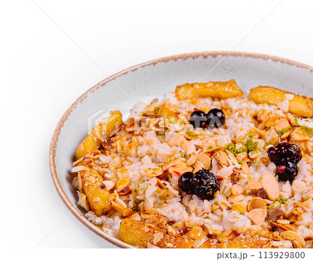 Muesli with dried fruits and milk in ceramic bowl 113929800