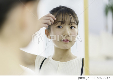 朝鏡を見て前髪を気にする小学生の女の子 朝鏡を見て前髪を気にする小学生の女の子 113929937