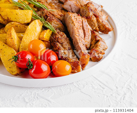 Grilled kebab pork meat with roasted potato and vegetables Grilled kebab pork meat with roasted potato and vegetables 113931404