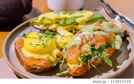 Toast and croissant with salmon, poached egg and avocado 113931539