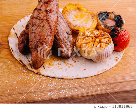 Grilled Tenderloin steak with vegetables on wood Grilled Tenderloin steak with vegetables on wood 113931969