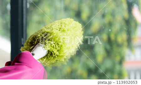 Human hand in protective glove wiping using a duster 113932053
