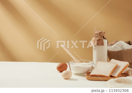 Copy space photo of baking homemade cake on light brown background with some essential ingredients for cooking, culinary concept, copy space, front view 113932308
