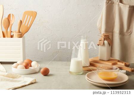Minimals white background against baking ingredients and utensils with fresh milk and eggs. Besides good measuring spoons, the key to baking success is fresh, good-quality ingredients 113932313
