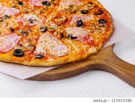 pizza with ham and mushrooms on a light background pizza with ham and mushrooms on a light background 113932396
