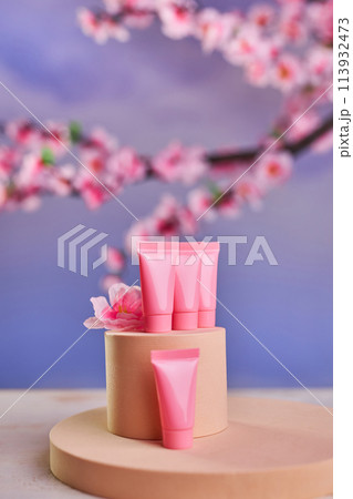 Pink tubes for cosmetics and branches of cherry blossoms Pink tubes for cosmetics and branches of cherry blossoms 113932473