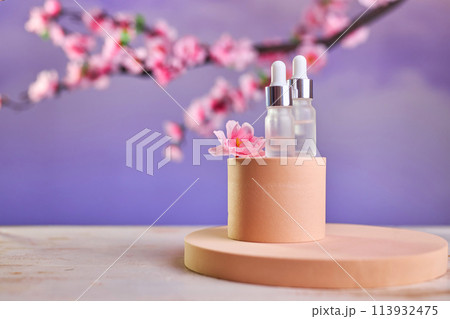 Glass bottle with pipette and serum on a podium 113932475
