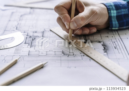 Architectural engineering design plan drawing on the table. Architect's work on table in studio. Construction design and plan 113934523