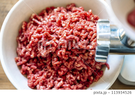 Minced meat and electric meat grinder. Cooking beef minced in the kitchen with an electric grinder 113934526