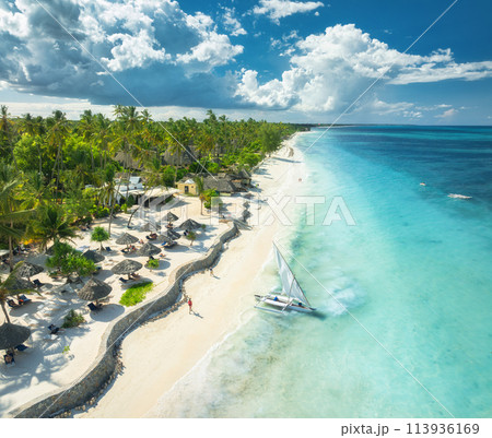 Aerial view of the sailboat on blue sea, empty white sandy beach 113936169