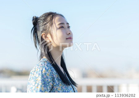 空を見上げる若い女性　横顔 113936202