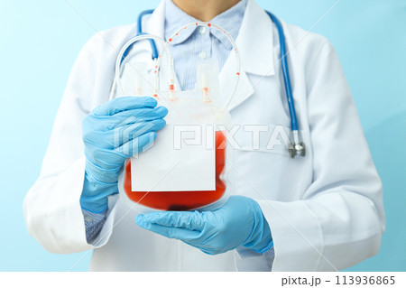 Doctor with bag with donor blood in hands on blue background, close up 113936865