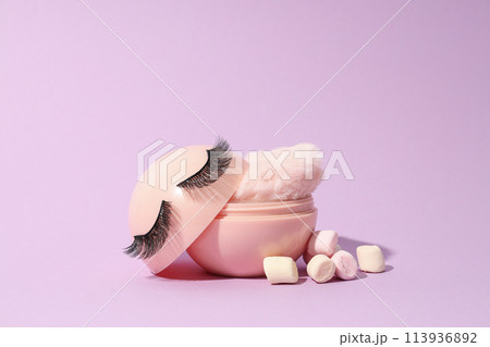 A bottle of loose powder, light shade, on a purple background. 113936892