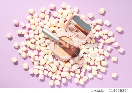 A bottle of loose powder, light shade, on a purple background. 113936894