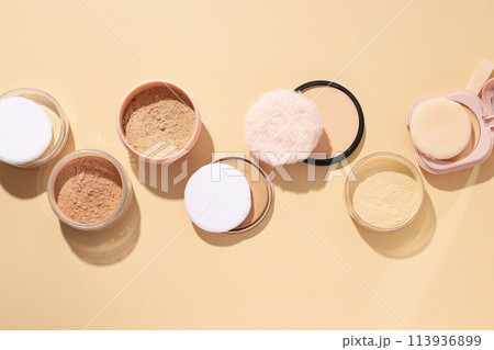 Bottles of face powder, different shades, on a pastel background. Bottles of face powder, different shades, on a pastel background. 113936899