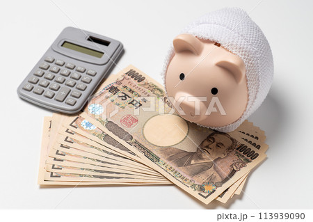 包帯に巻かれた貯金箱と医療費のイメージ 113939090