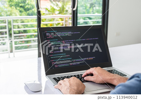 A man is typing on a laptop computer A man is typing on a laptop computer 113940012