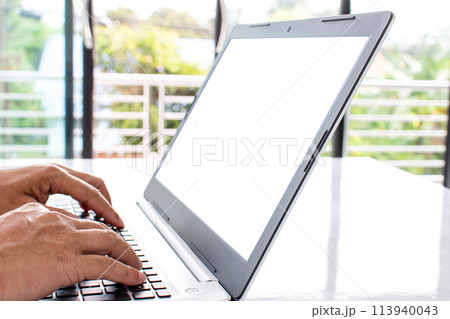 A person is typing on a laptop with a blank screen A person is typing on a laptop with a blank screen 113940043