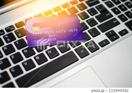 A credit card is displayed on a laptop keyboard A credit card is displayed on a laptop keyboard 113940562
