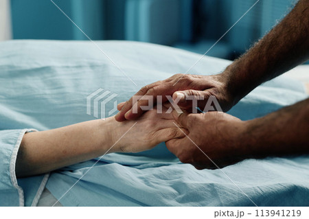 Unrecognizable male doctor holding hand of mature Caucasian woman before CT scan procedure in modern clinic 113941219