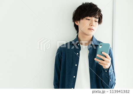 スマホを操作する男性 113941382
