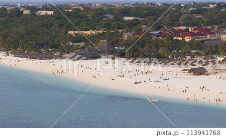 Kendwa beach with a lot of people and a boat in the water Kendwa beach with a lot of people and a boat in the water 113941768