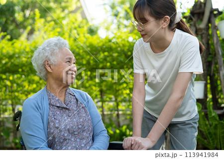 Caregiver help and care Asian elderly woman use walker with strong health while walking at park in happy fresh holiday. 113941984