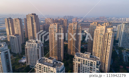 Aerial drone shot over residential apartment buildings on sunset. Aerial shot over community apartment complex in China. Aerial drone shot over residential apartment buildings on sunset. Aerial shot over community apartment complex in China. 113942279