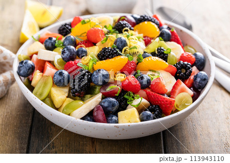 Fruit salad on a wooden table with berries and honey dressing Fruit salad on a wooden table with berries and honey dressing 113943110