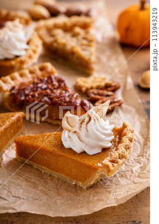 Variety of Thanksgiving pie slices on parchment paper Variety of Thanksgiving pie slices on parchment paper 113943219