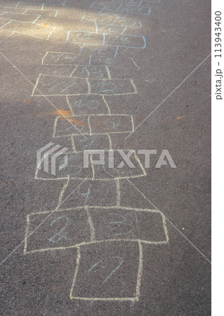 Chalk drawings on asphalt. Hopscotch game concept. Childhood concept. Painted numbers on the road. Outdoor games. Children activity. Outdoor playground in the city. Colourful hopscotch line. Chalk drawings on asphalt. Hopscotch game concept. Childhood concept. Painted numbers on the road. Outdoor games. Children activity. Outdoor playground in the city. Colourful hopscotch line. 113943400