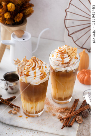 Pumpkin caramel iced latte with whipped cream and caramel syrup 113943465