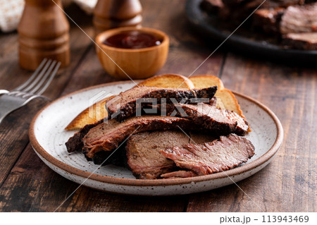 Sliced smoked brisket on a plate with toast Sliced smoked brisket on a plate with toast 113943469