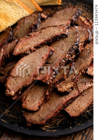 Sliced smoked brisket on a serving plate with toast Sliced smoked brisket on a serving plate with toast 113943474