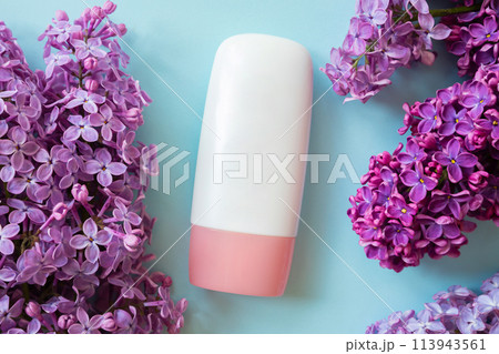 cosmetic moisturizer tube bottle with pink screw cap, lilac flowers a lot on blue background. cream, gel, skincare, shampoo, lotion, balsam, toothpaste. blank tube template mockup, bottle container cosmetic moisturizer tube bottle with pink screw cap, lilac flowers a lot on blue background. cream, gel, skincare, shampoo, lotion, balsam, toothpaste. blank tube template mockup, bottle container 113943561