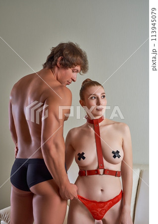 Sexy couple in role playing game costumes with harness at home 113945079