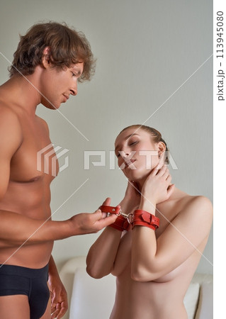 Woman enjoying BDSM role play while man teasing her Woman enjoying BDSM role play while man teasing her 113945080