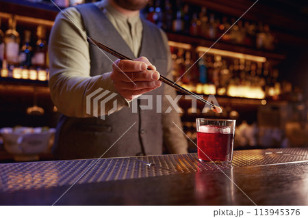 Bartender working at bar counter closeup view on hands Bartender working at bar counter closeup view on hands 113945376